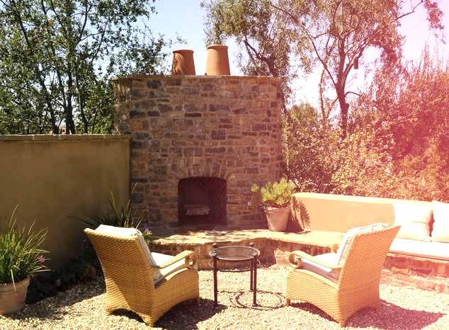 Large tuscan backyard gravel patio photo with a fire pit and no cover